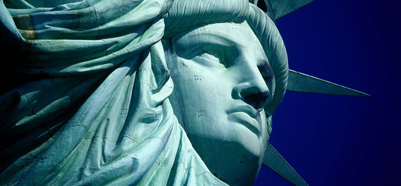 An up-close image of the face of the Statue of Liberty in New York Harbor at Dawn